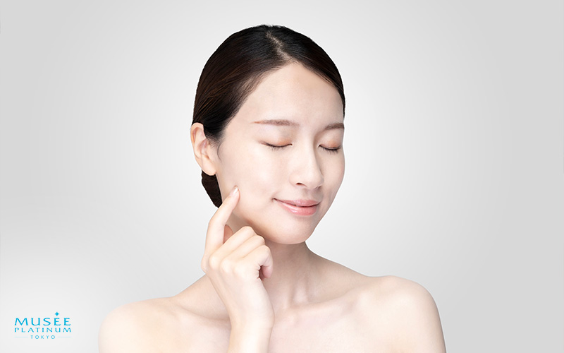 Woman touching clear calm skin after treatment.